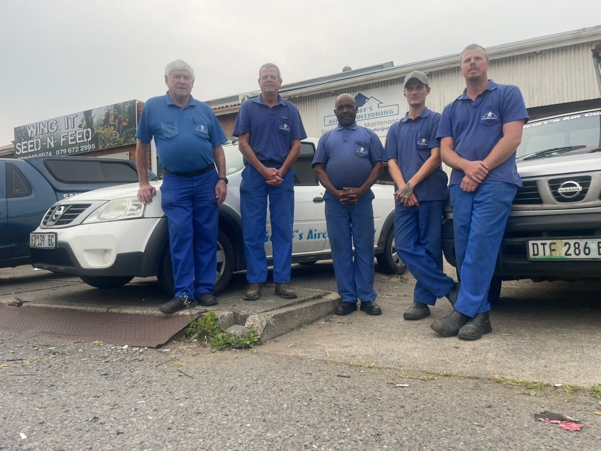 The Geoff's Air Conditioning crew of five standing beside their two service bakkies outside the Arcadia workshop